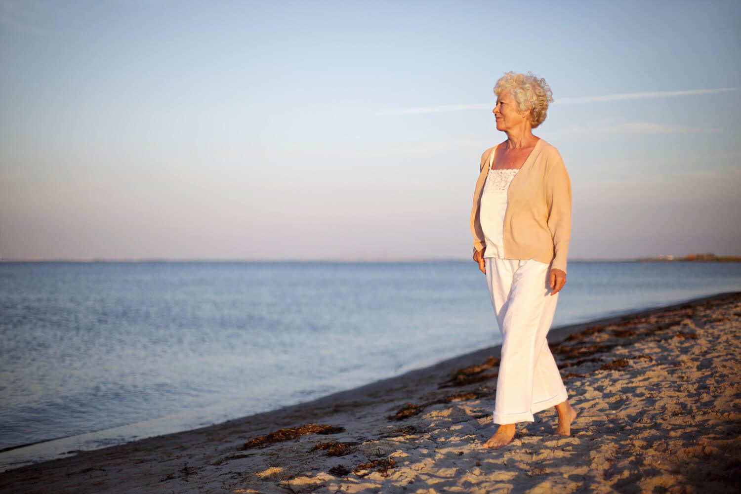 senior woman walking on beach
